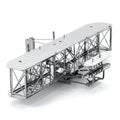 Maquette métallique du Wright Flyer en vue trois-quarts avant, mettant en valeur la charpente ajourée, les ailes superposées et le moteur central emblématique